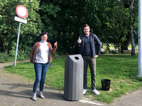 Mascha en Alain aan de nieuwe vuilbak die de emmer van de buurtbewoner vervangt.